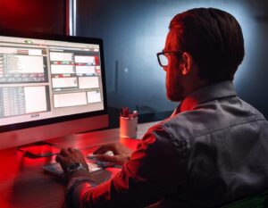 Close up of a worker looking through a portal at a desk.